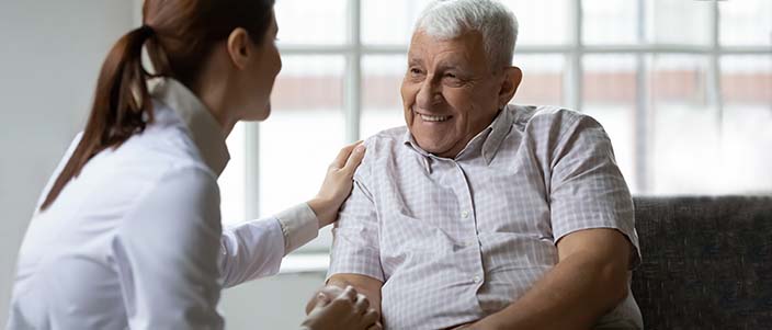 elderly man smiling at healthcare professional
