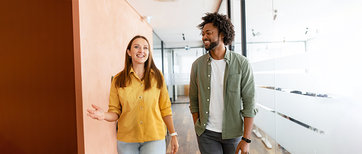 Healthy, smiling employees walking down a hallway.