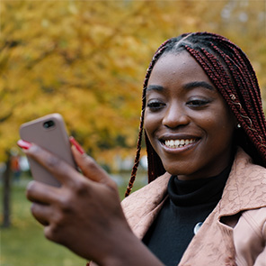Smiling woman looks at her phone as she checks her step count.