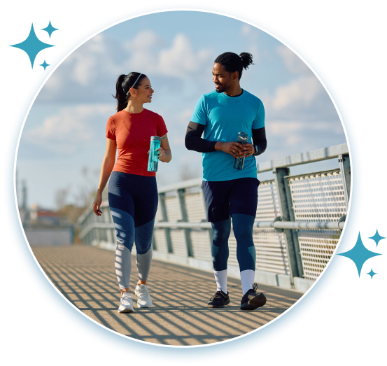 Man and woman walk along a pathway in the warm sunshine.