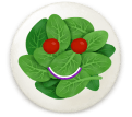 Plate of spinach with 2 cherry tomatoes and a slice of onion which make a smiling face