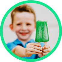 Smiling boy holds up a dreamsicle.