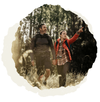 Man and woman hiking in a forest.