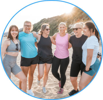 Friends standing arm and arm outside in the sunshine.